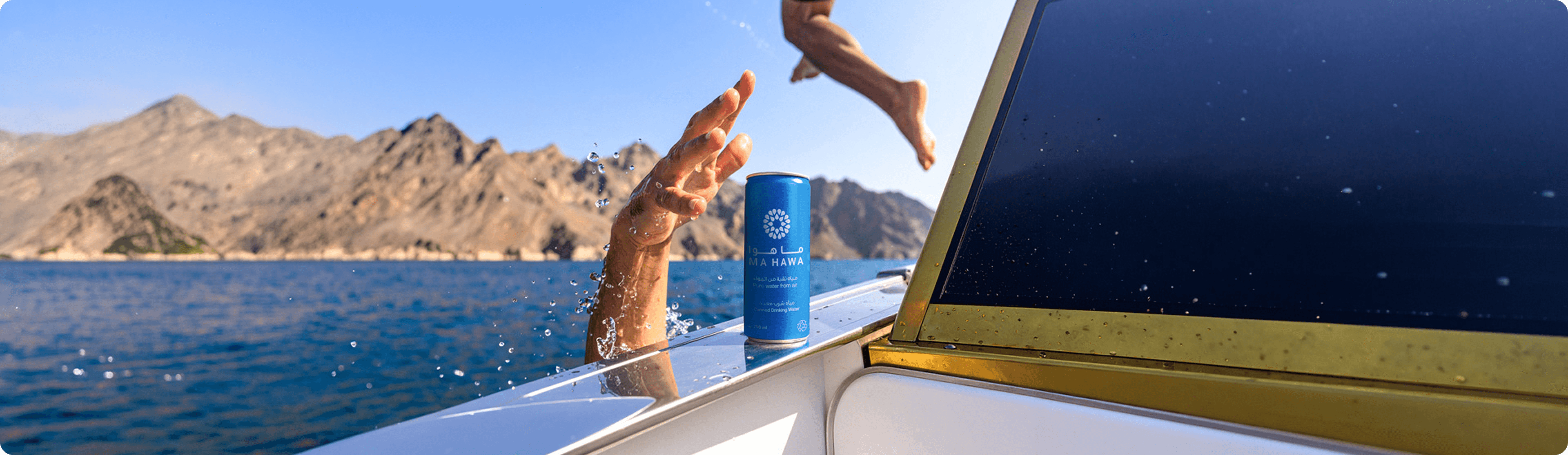 Hand catching water with a Ma Hawa can, mountains in background